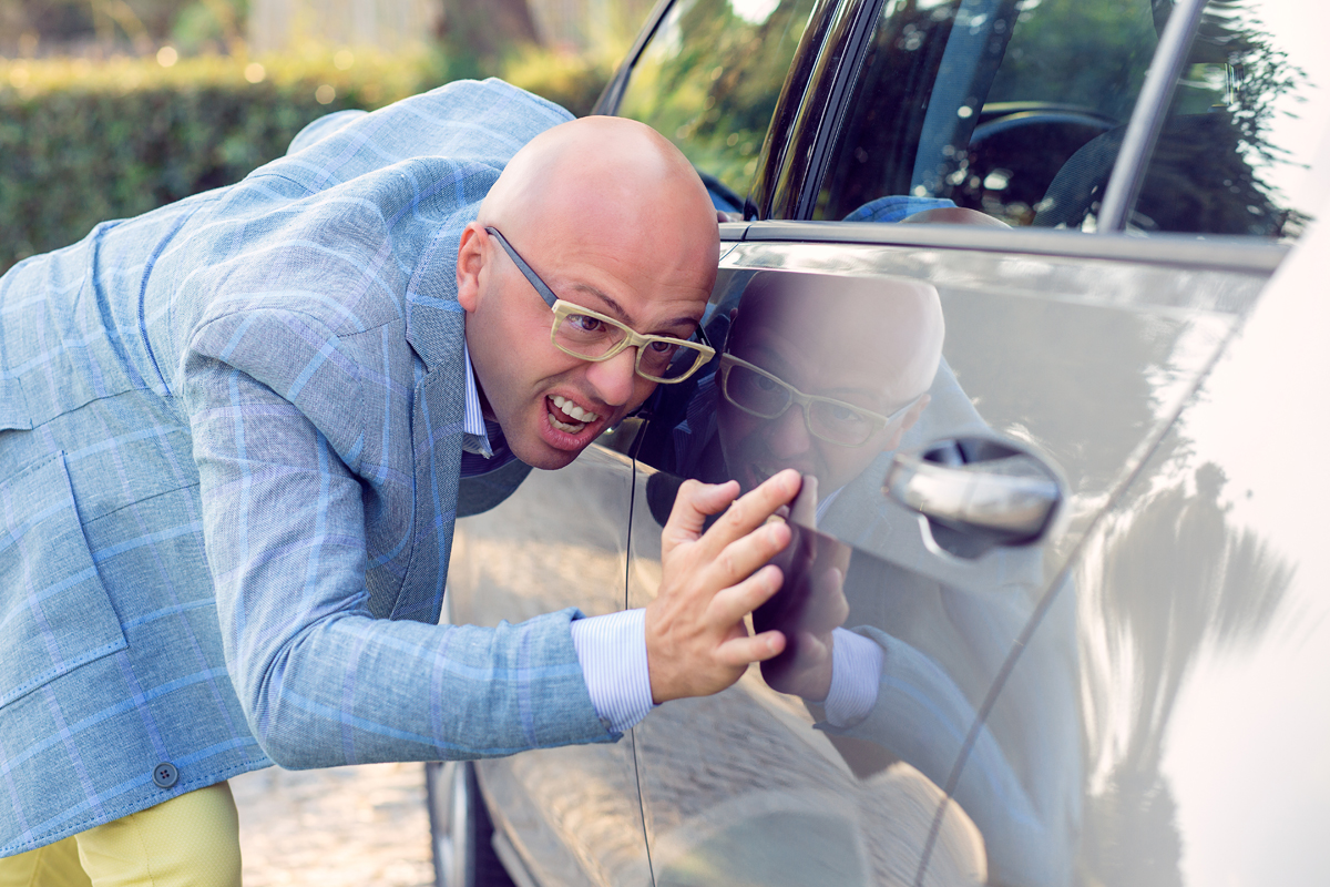 man conducting a thorough inspection of his vehicle after car shipping.